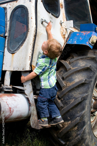 Photo: Kleiner Junge klettert auf Traktor Kleiner Junge klettert auf Traktor