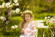 Photo: Little girl in spring garden wearing a chaplet Little girl in spring garden wearing a chaplet