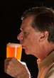 Senior man sipping from pint glass beer