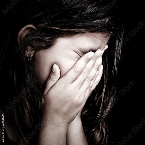 Foto: Grunge portrait of a girl crying on a black background Grunge portrait of a girl crying on a black background
