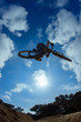 Biker jumping against sun