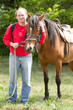 Handsome smiling man with horse in the forest
