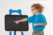 Little cute boy with glasses shows Einstein's formula