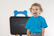 Little boy shows tongue as Einstein near formula on a blackboard
