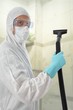 Mann in Schutzanzug mit Sauger bei der Arbeit