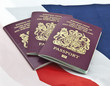 Three United Kingdom passports on folded Union Jack Flag