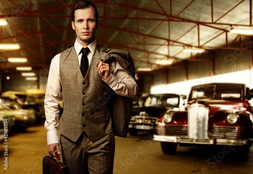 Photo: Businessman with a briefcase in garage Businessman with a briefcase in garage