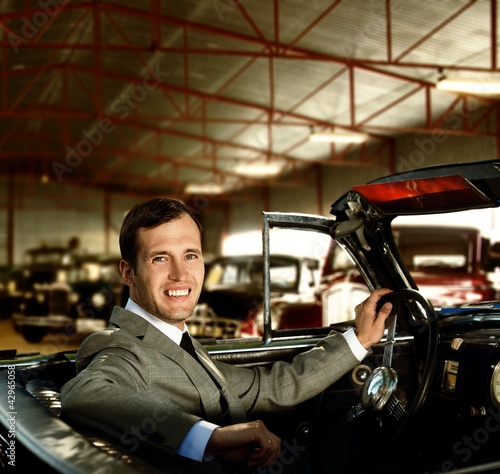 Photo: Man behind wheel in a retro car Man behind wheel in a retro car