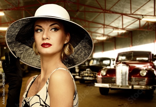 Photo: Woman in hat in retro garage Woman in hat in retro garage