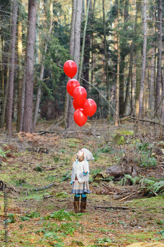 Foto: Mädchen mit roten Luftballons im Wald Mädchen mit roten Luftballons im Wald