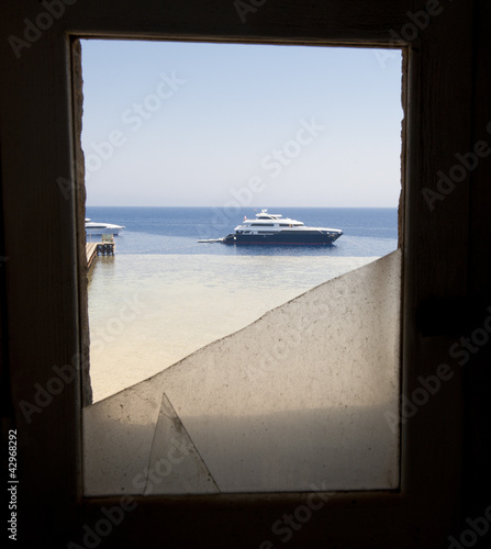 Photo: View of boat through broken window View of boat through broken window