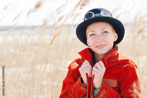 Photo: Happy woman wearing hat front of the reed Happy woman wearing hat front of the reed