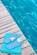 tongues et serviette sur passerelle de piscine