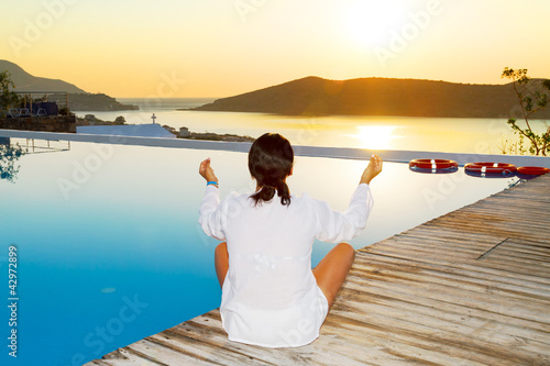 Photo: Woman meditating at sunrise in Greece Woman meditating at sunrise in Greece