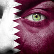 Flag painted on face with green eye to show Qatar support