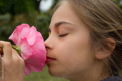 Photo: fillette sentant une rose fillette sentant une rose