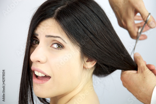 Foto: Beautiful woman screaming while her long hair are cut Beautiful woman screaming while her long hair are cut