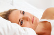 Frau liegt wach im Bett. Schlaflos und nachdenklic