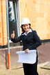 Architekt mit Bauplan auf Baustelle