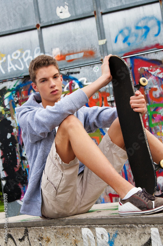 Foto: Cool blickender Jugendlicher Mann vor Graffiti Cool blickender Jugendlicher Mann vor Graffiti