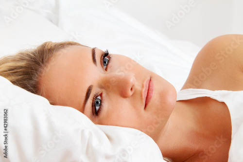 Photo: Frau liegt wach im Bett. Schlaflos und nachdenklic Frau liegt wach im Bett. Schlaflos und nachdenklic