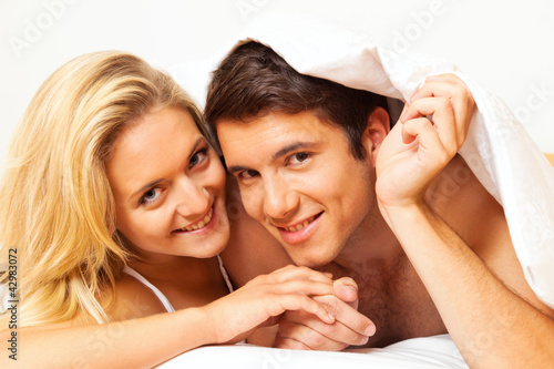 Photo: Paar hat Spass im Bett. Lachen, Freude und Erotik Paar hat Spass im Bett. Lachen, Freude und Erotik