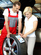 Foto: Motor mechanic explains to a customer tire labeling in a garage Motor mechanic explains to a customer tire labeling in a garage