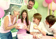 Photo: A girl happily receiving her birthday present from her mother while the others watching A girl happily receiving her birthday present from her mother while the others watching