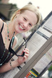 Photo: A lady holding her sunglasses smiling at the camera A lady holding her sunglasses smiling at the camera