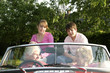 An old couple taking their grandchildren for a car ride