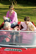 An old couple taking their grandchildren for a car ride