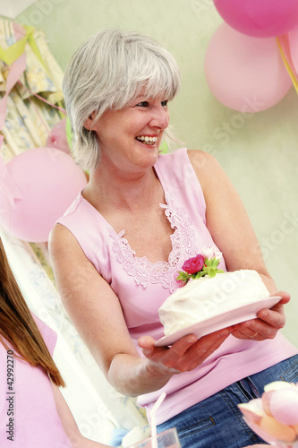 Photo: A woman holding a birthday cake A woman holding a birthday cake