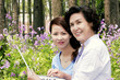 A woman and her mother using laptop in a park 