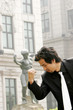 Man in business suit imitating a statue's pose 