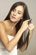 Woman in towel combing her hair 