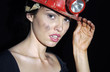 Woman with dirty face wearing a safety helmet 