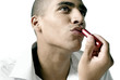 Man applying lipstick on his lips