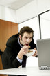 Businessman checking his work while eating breakfast cereal