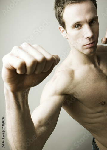 Photo: Shirtless man striking a kung fu pose for the camera Shirtless man striking a kung fu pose for the camera