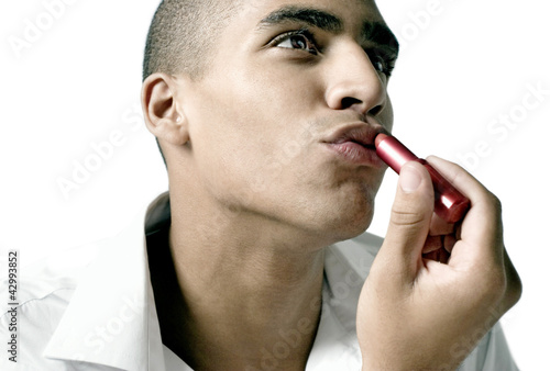 Photo: Man applying lipstick on his lips Man applying lipstick on his lips
