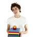 Boy carrying a stack of books with a red apple on top