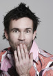 Man with hand covering mouth
