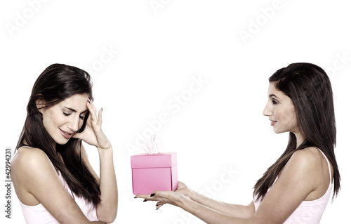 Photo: Woman giving her friend a gift Woman giving her friend a gift