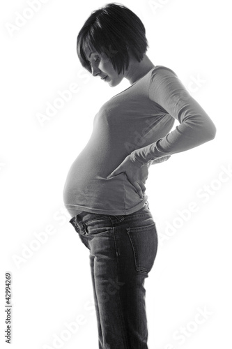 Photo: Pregnant woman in jeans, side view Pregnant woman in jeans, side view