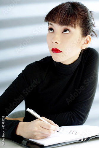 Photo: Businesswoman writing in an organizer Businesswoman writing in an organizer