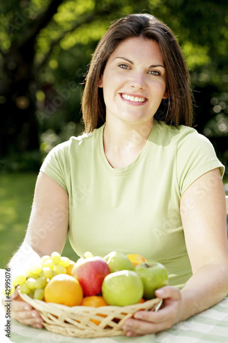 Photo: Woman with a basket of fruits Woman with a basket of fruits