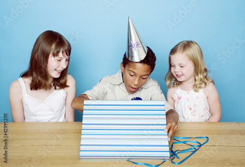 Photo: Boy unwrapping his present Boy unwrapping his present