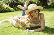 Teenage girl lying forward on the field with her cat
