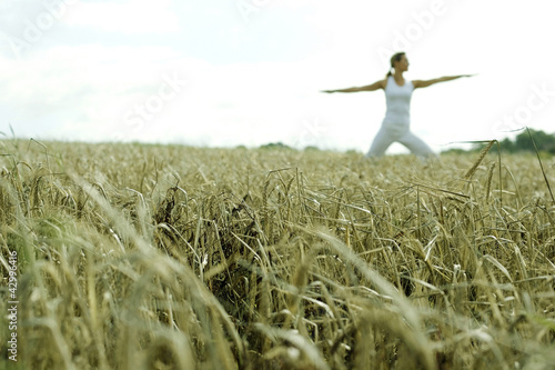 Photo: Woman practicing yoga on the field Woman practicing yoga on the field