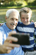Senior man taking picture with his grandson